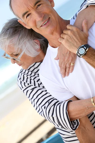 Casal de meia-idade abraçando na praia — Fotografia de Stock