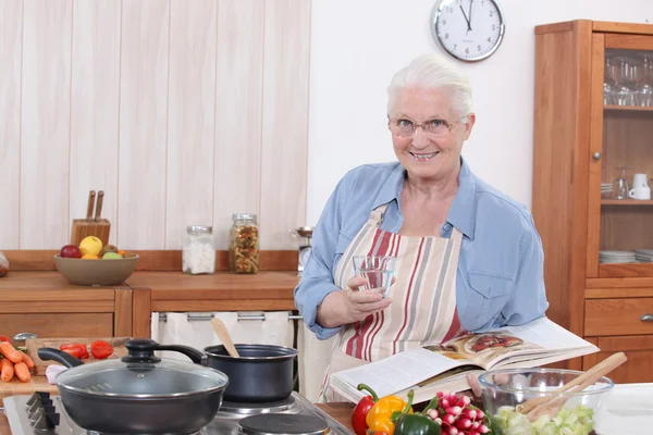 Stará žena vaří — Stock fotografie