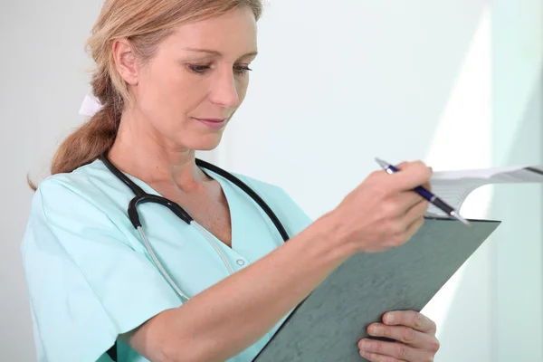 Enfermera rubia sosteniendo portapapeles —  Fotos de Stock