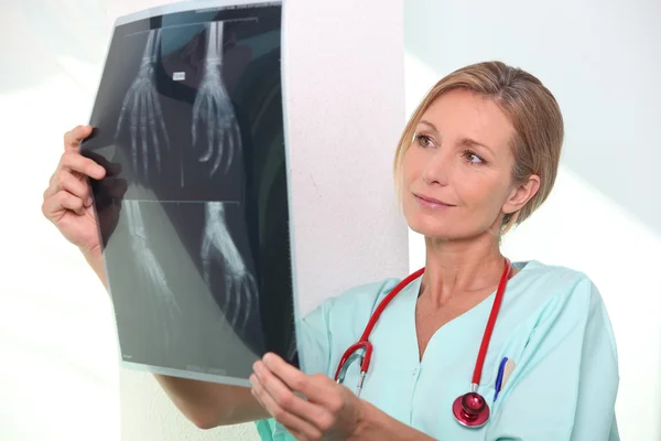 Krankenschwester schaut auf Röntgenbild — Stockfoto