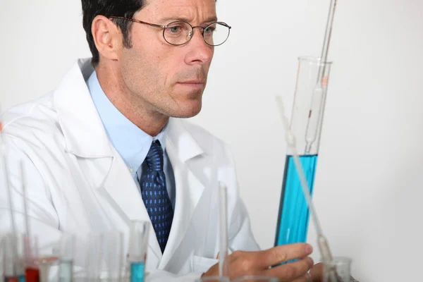 Cientista olhando para tubo de ensaio — Fotografia de Stock