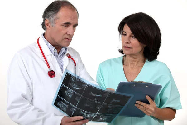 Médico e enfermeiro discutindo um raio-x — Fotografia de Stock
