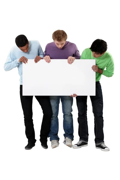 Young men holding up a blank sign Stock Image