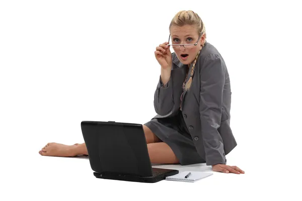 Businesswoman sitting on the floor and working on her laptop Royalty Free Stock Photos