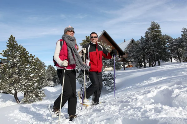 Casal trekking através da neve — Fotografia de Stock