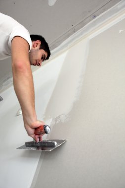 Tradesman spreading plaster clipart