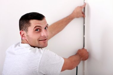 Man fixing wire to wall clipart