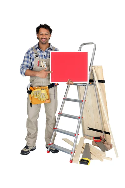 Carpenter holding red sign — Stock Photo, Image
