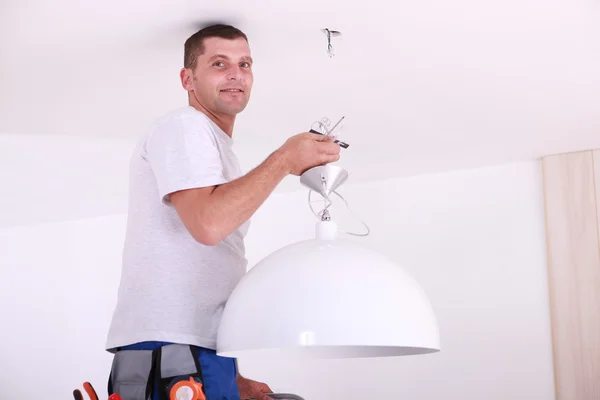 Hombre instalando una luz de techo —  Fotos de Stock