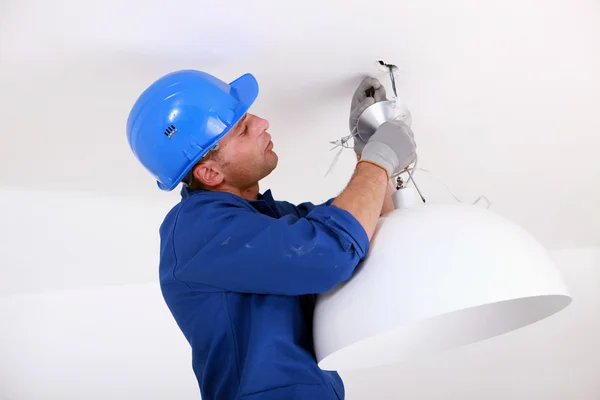Electricista instalando una luz de techo — Foto de Stock