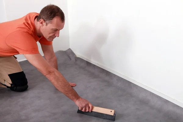 Uomo montaggio di un pavimento lino — Foto Stock