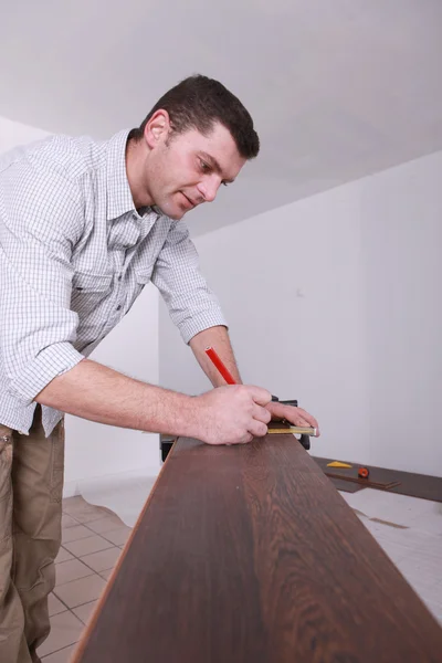 Man marking parquet floor before cutting to size — Stock Photo, Image