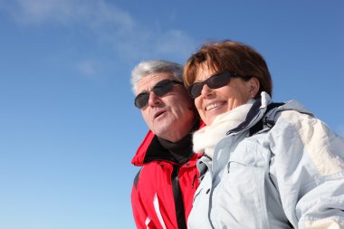 Retired couple in skiwear clipart