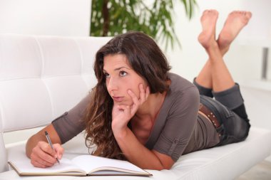 Woman writing in her diary clipart