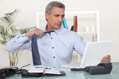 Man undoing his tie at the end of the day clipart