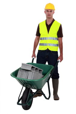 Man pushing waste material in wheelbarrow clipart