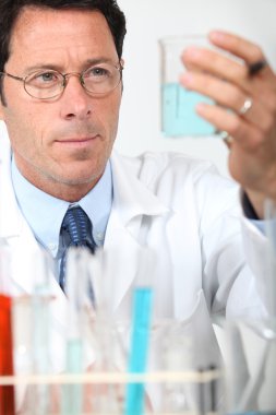 Male scientist holding glass beaker clipart