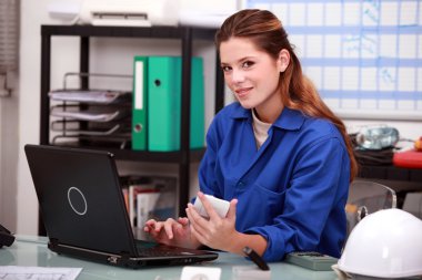 Female construction worker in office clipart