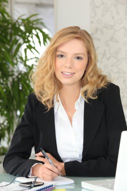 A receptionist writing in her notebook clipart