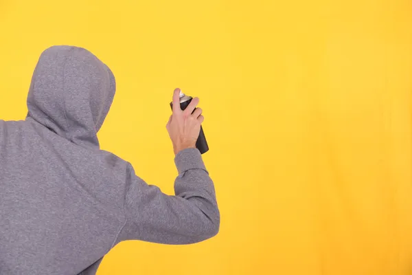 Man in a hoodie spray painting — Stock Photo, Image