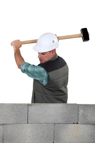 Un homme heurte un mur avec un marteau — Photo