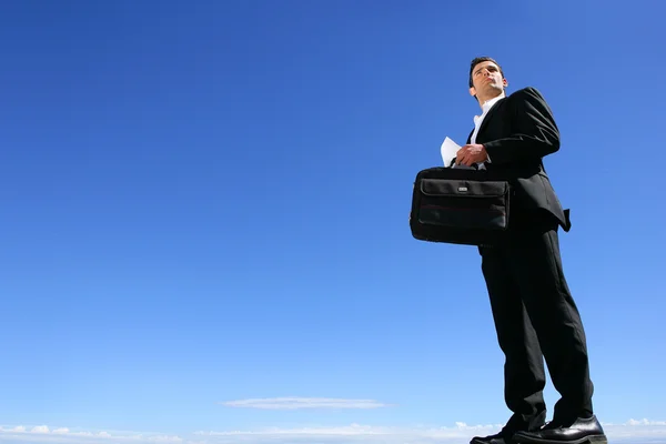 Mavi gökyüzünün önünde akıllı iş adamı — Stok fotoğraf