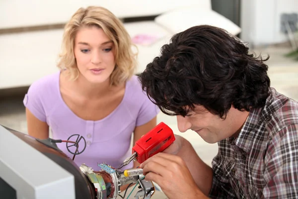Couple repairing television — Stock Photo, Image