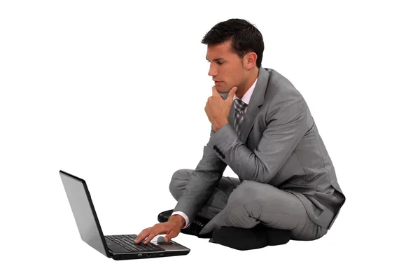 Üzletember ül határon lábakkal a laptop — Stock Fotó