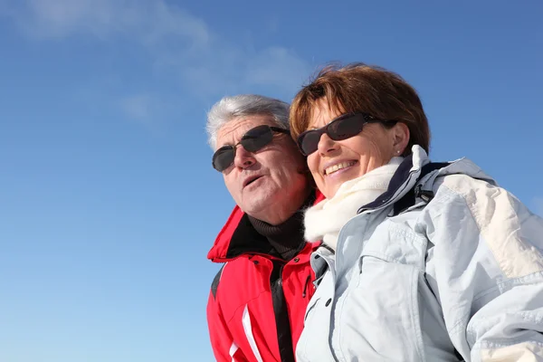 Důchodci pár v lyžařské oblečení — Stock fotografie