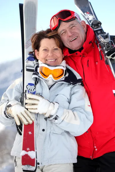 Older couple with skis — Stock Photo, Image