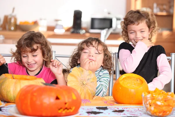 Giggling girls carving pumpkins — Stock Photo, Image