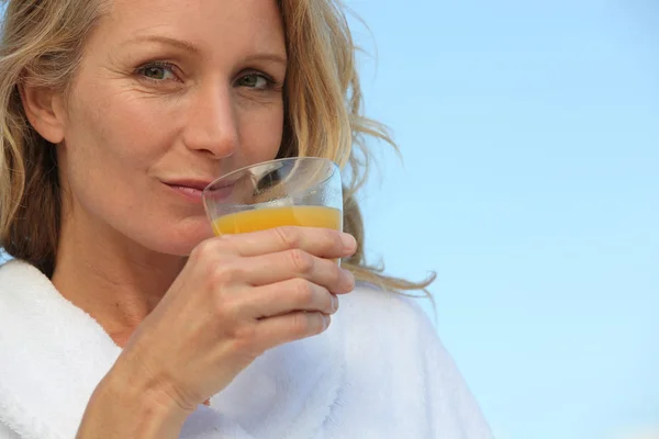 Γυναίκα πίνοντας χυμό πορτοκαλιού γυαλί — Φωτογραφία Αρχείου