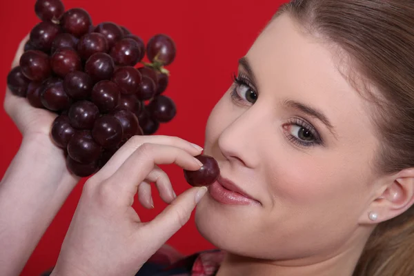 Retrato de rubia comiendo uvas rojas —  Fotos de Stock