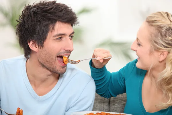 Женщина кормит мужа едой — стоковое фото