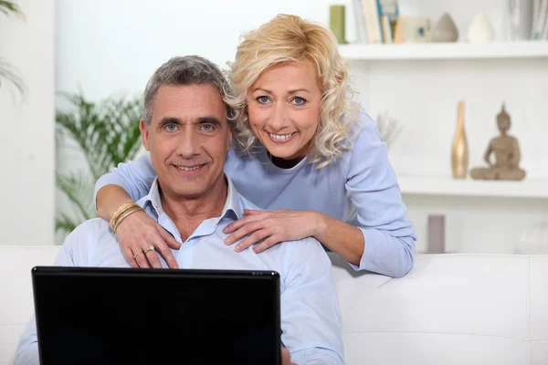 Reif pärchen mit laptop bei zuhause — Stockfoto