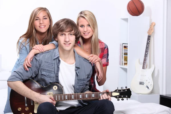 Três adolescentes no quarto com guitarra elétrica — Fotografia de Stock