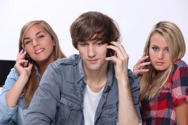 Üç genç cep telefonları üzerinde konuşuyor — Stok fotoğraf