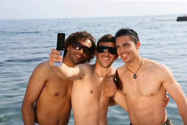 Jeunes hommes prenant des photos à la plage — Photo