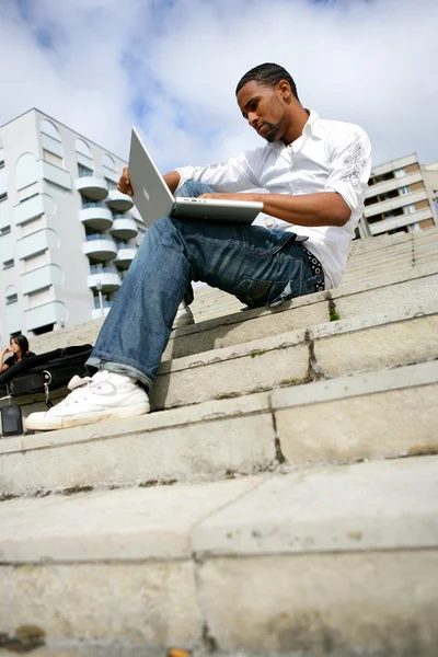 Afro-amerikai ember ült a lépcsőn, laptop — Stock Fotó