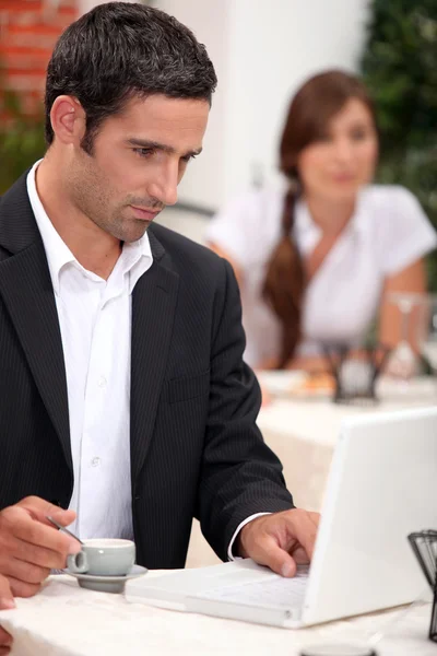 Hombre con portátil en un restaurante — Foto de Stock