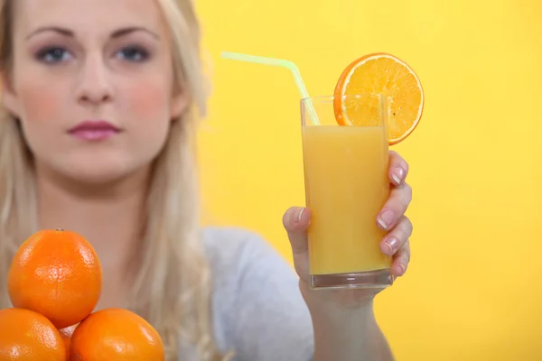 Donna con succo d'arancia di vetro — Foto Stock