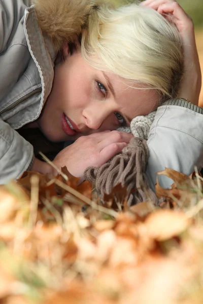 Kvinna liggande på en höstlig skog våning — Stockfoto
