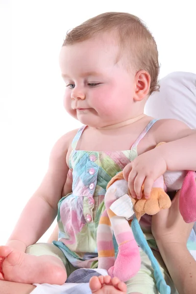 Baby girl being held in a sitting position and looking at her feet — Stock Photo, Image