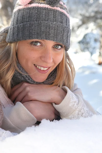Mladá žena ležící ve sněhu — Stock fotografie