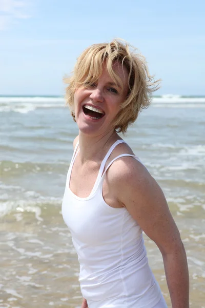 Blond kobieta zabawa na plaży — Zdjęcie stockowe