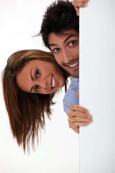 Νεαρή γυναίκα και άνδρα που κρύβεται πίσω από την πόρτα — Φωτογραφία Αρχείου