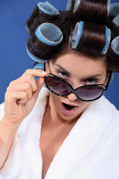 Mujer con rizador con bata de baño y gafas de sol —  Fotos de Stock