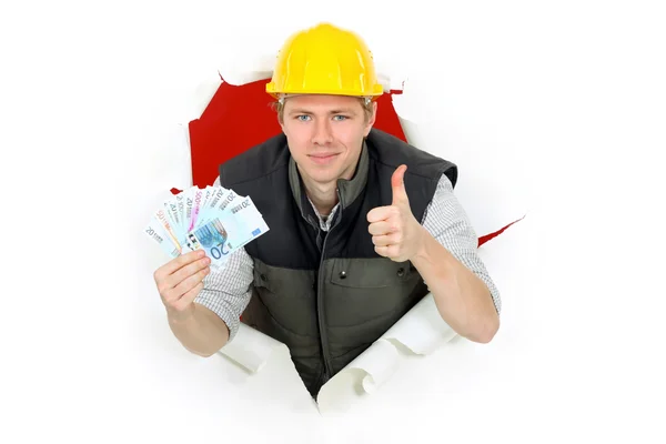 Thumbs up van een bouwer die houden van contant geld — Stockfoto