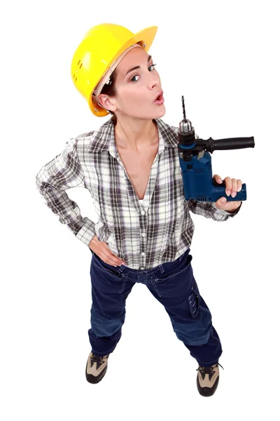 Uma trabalhadora da construção usando uma broca como arma . — Fotografia de Stock