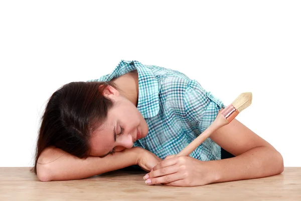 Mujer con un cepillo durmiendo en un escritorio —  Fotos de Stock